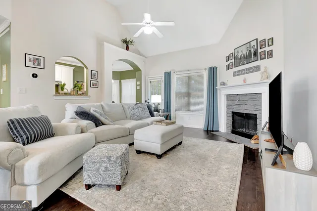 a living room with furniture a fireplace and a chandelier