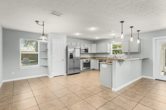 a kitchen with stainless steel appliances granite countertop a stove a refrigerator and a sink