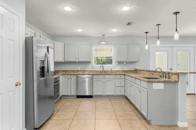 a kitchen with granite countertop white cabinets and a window