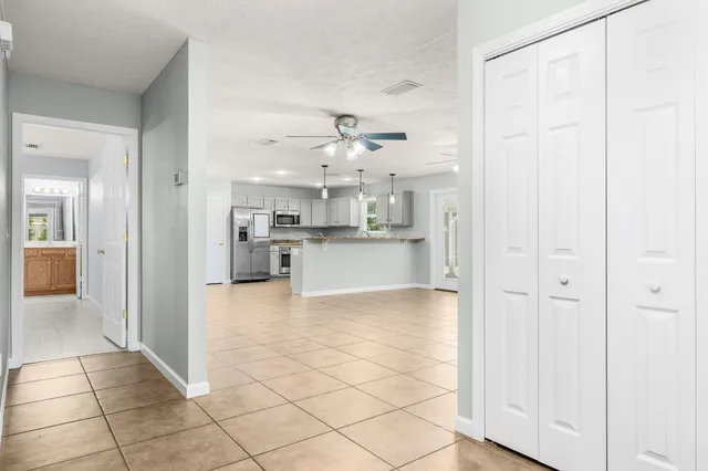 a view of a kitchen with furniture and chandelier fan
