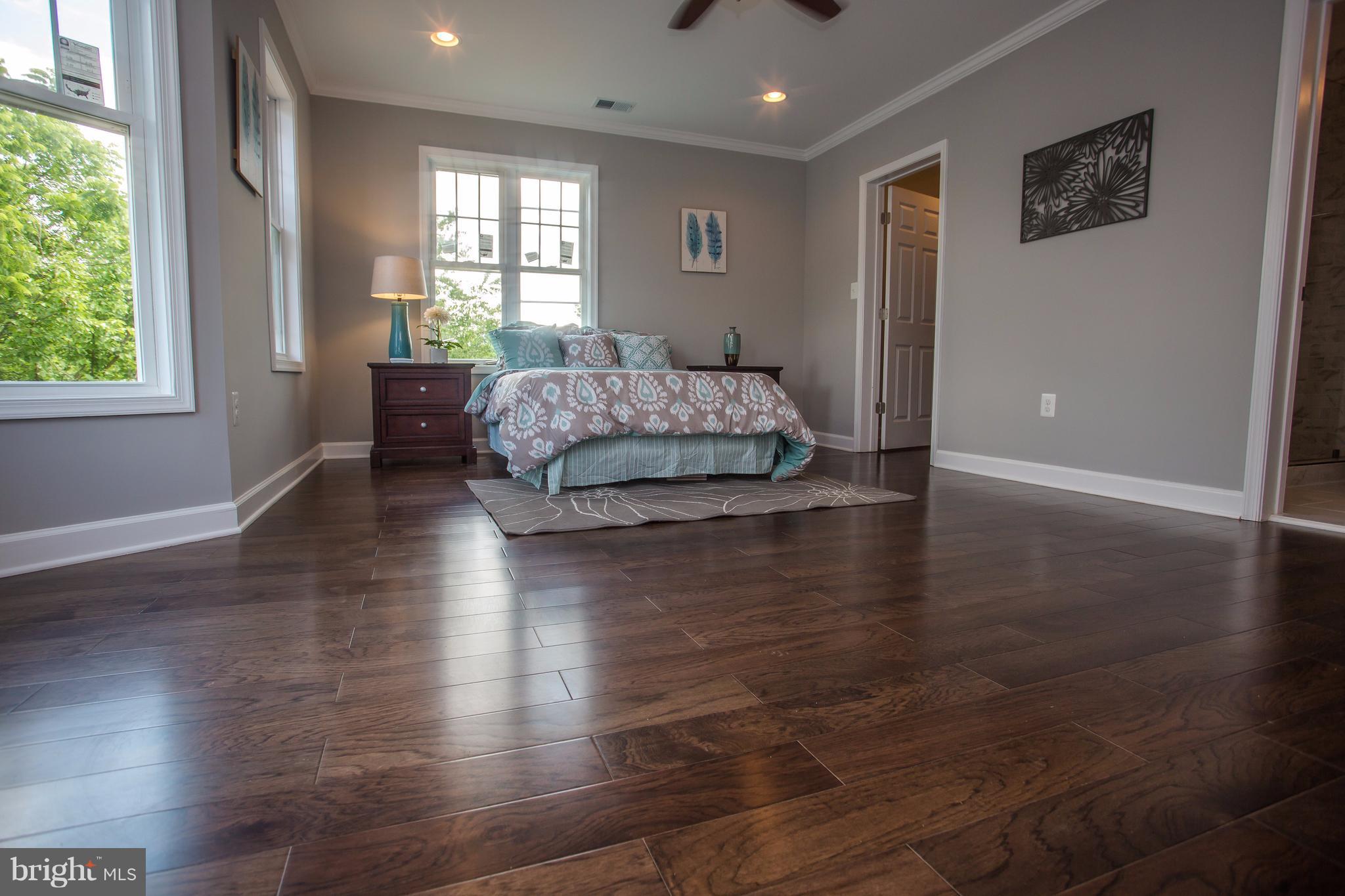 6445 First Street Alexandria, VA 22312 - Photo 12 of 28 a spacious bedroom with a balcony a bed and wooden floor