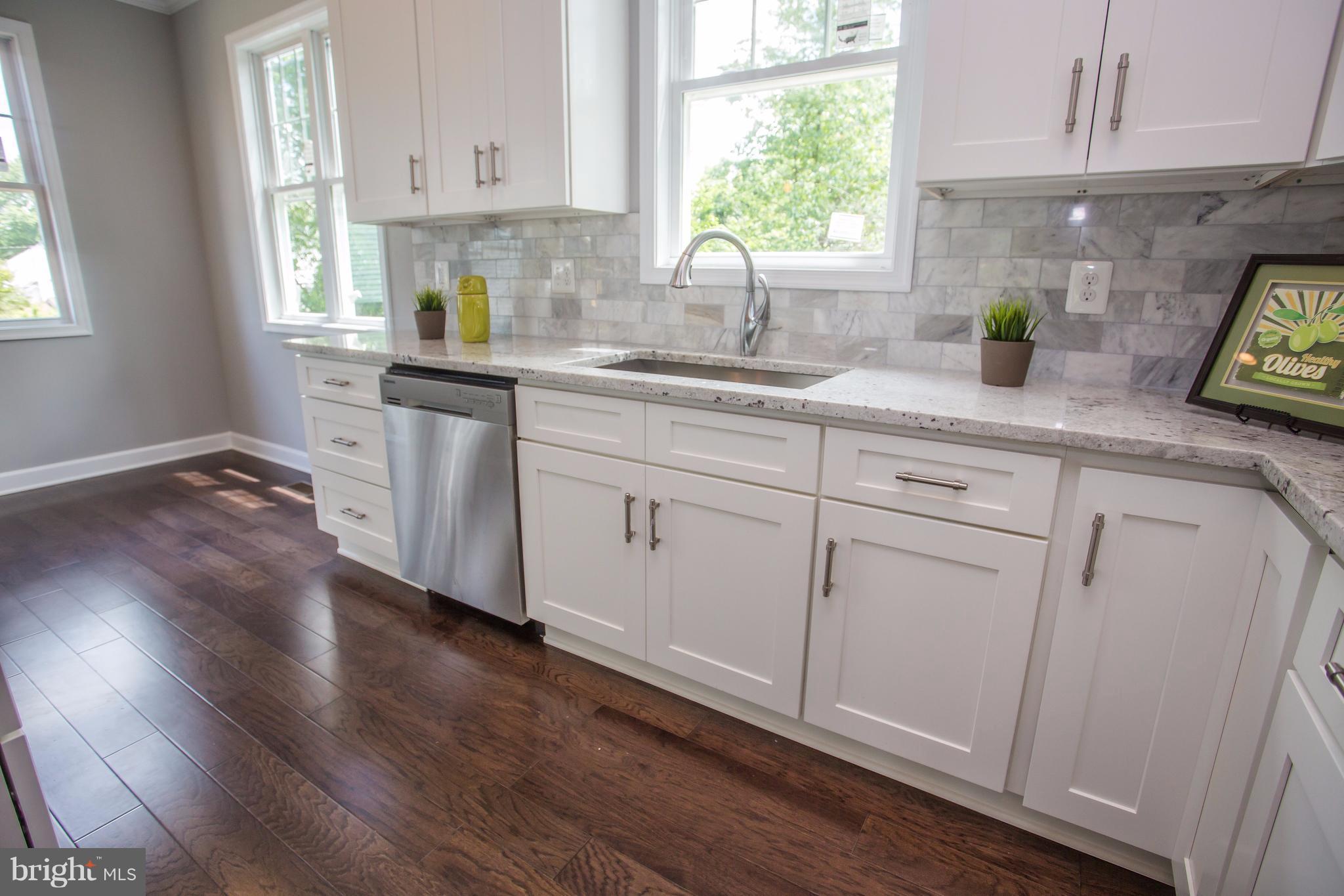 6445 First Street Alexandria, VA 22312 - Photo 5 of 28 a kitchen with white cabinets and a window