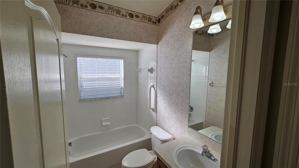 371 Quane Avenue Spring Hill, FL 34609 - Photo 22 of 45 a bathroom with a granite countertop bathtub shower sink vanity and a toilet