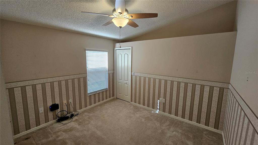 371 Quane Avenue Spring Hill, FL 34609 - Photo 26 of 45 a view of a hallway with a ceiling fan and a projector