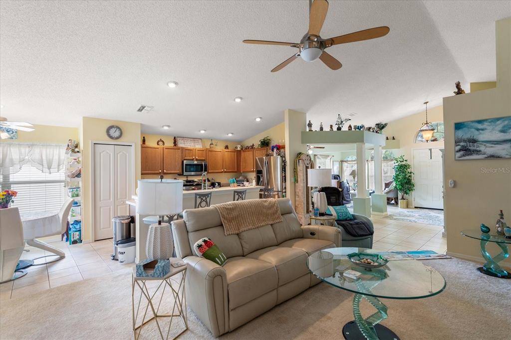 371 Quane Avenue Spring Hill, FL 34609 - Photo 32 of 45 a living room with furniture kitchen view and a chandelier