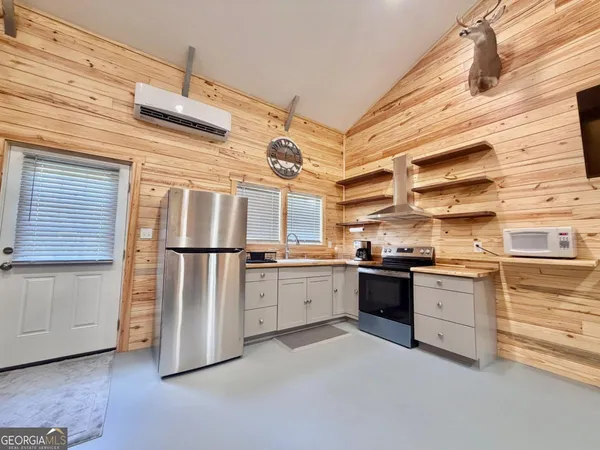 a kitchen with a stove and a wooden floor