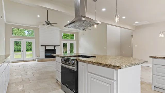 a kitchen with kitchen island granite countertop a stove and a sink