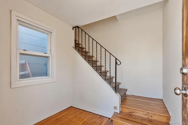 a view of a hallway with wooden floor and staircase