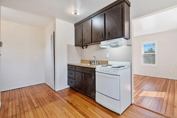 a kitchen with a stove cabinets and wooden floor