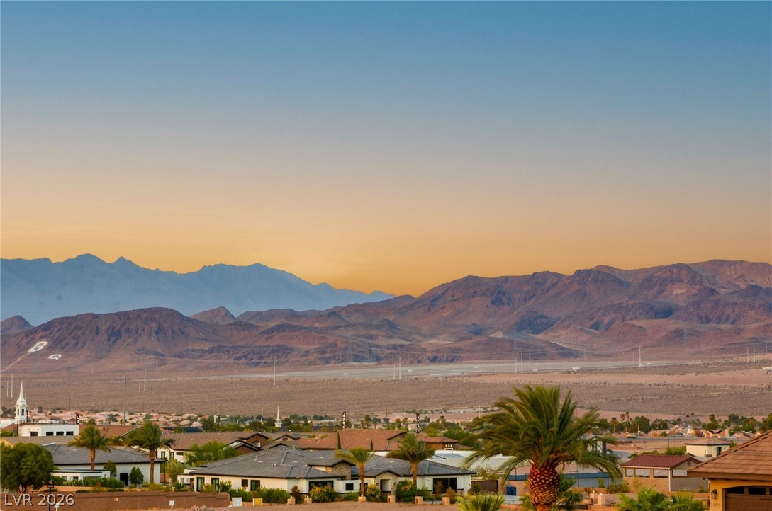 324 Wanda Road Henderson, NV 89002 - Photo 40 of 96 Dramatic mountain ranges rise behind a peaceful desert neighborhood during sunset.