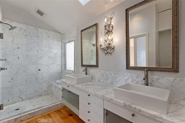 a bathroom with a granite countertop sink a mirror and a shower