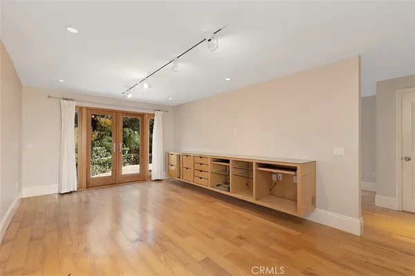 a view of an empty room with window and wooden floor