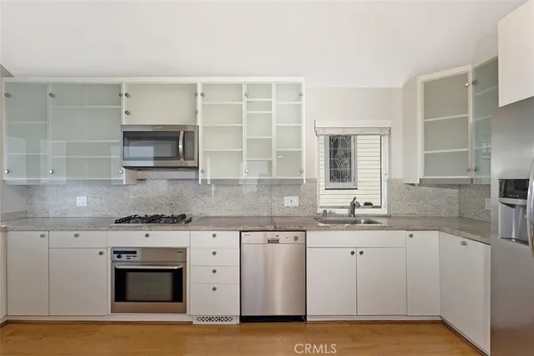 a kitchen with stainless steel appliances granite countertop a sink and a stove