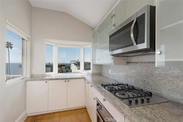 a kitchen with granite countertop a stove and a microwave