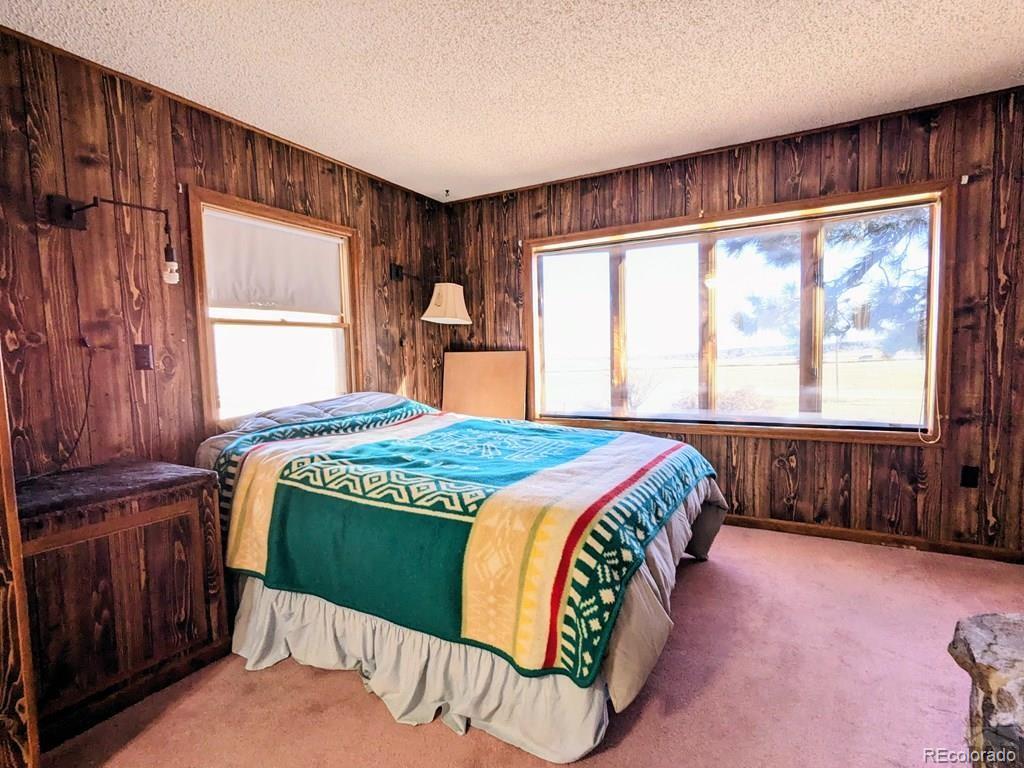 8140 Table Mountain Road Rye, CO 81069 - Photo 14 of 49 a bedroom with a bed and a large window