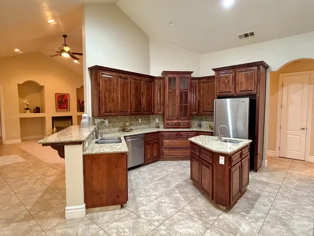 a kitchen with kitchen island granite countertop a sink stove and refrigerator