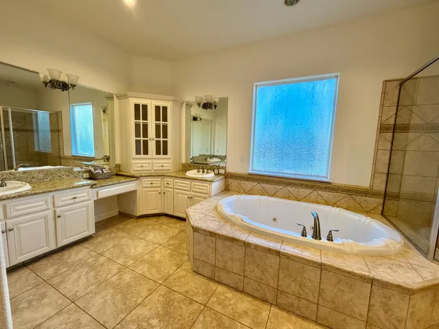 a bathroom with a tub a sink a mirror and a bathtub