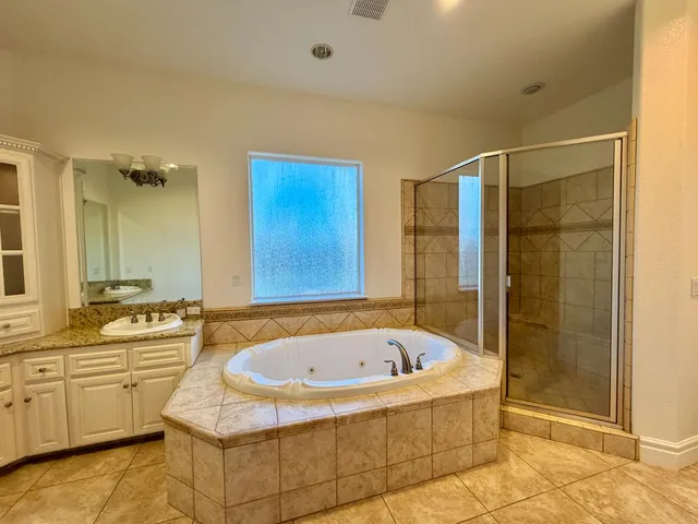 a bathroom with a tub a sink and a shower