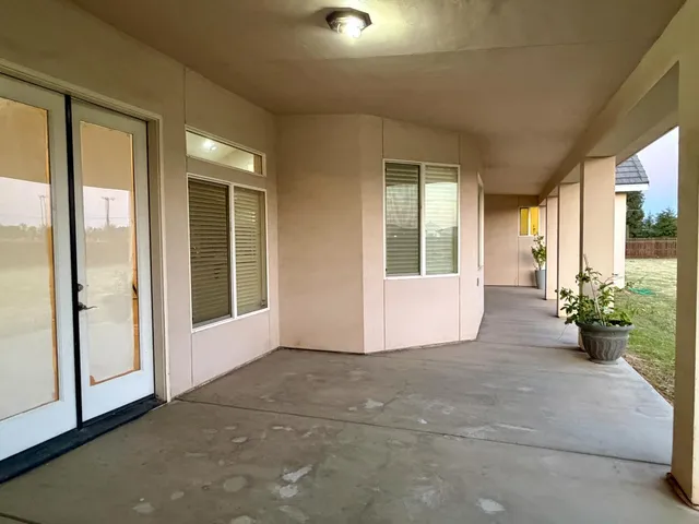 a view of a big room with windows and plants