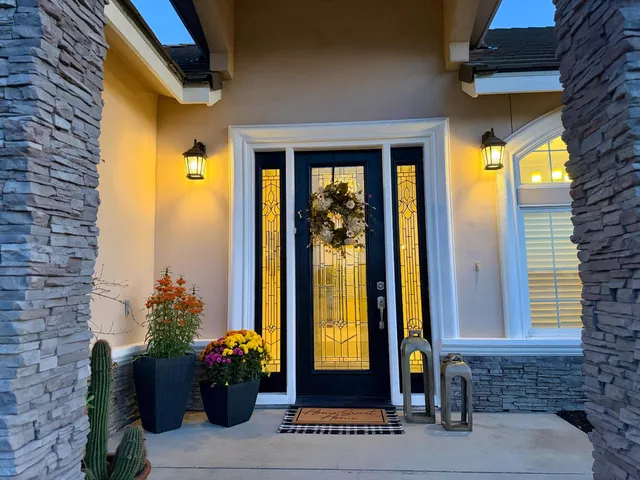 a front view of a house with a potted plant and a window