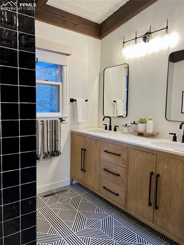 a bathroom with a double vanity sink a mirror and shower