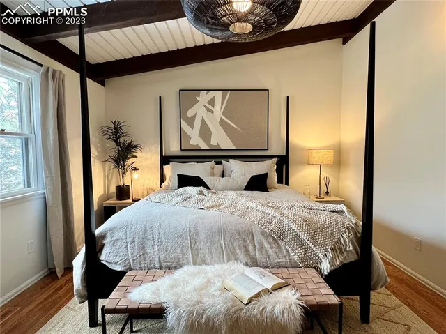 a bedroom with a bed and wooden floor