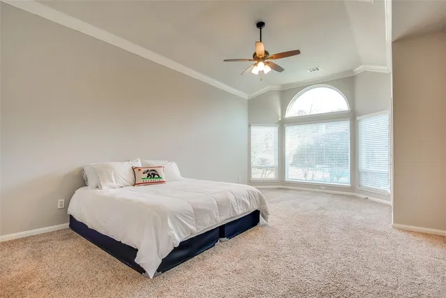 a bedroom with a bed and a large window
