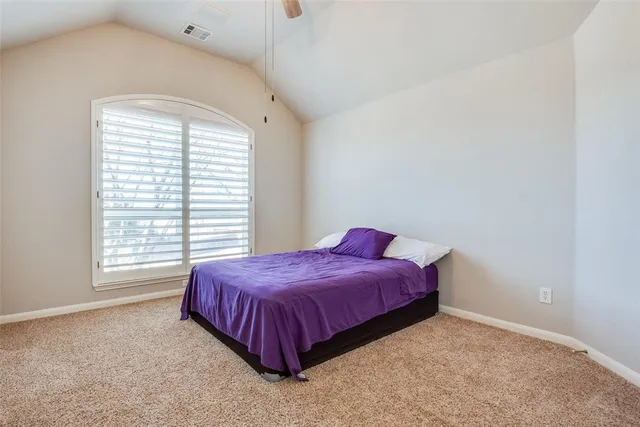 a spacious bedroom with a bed and a window