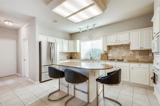 a kitchen with stainless steel appliances granite countertop a sink and cabinets