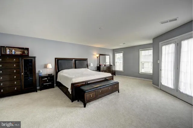 a large bed sitting in a bedroom next to a window and dresser