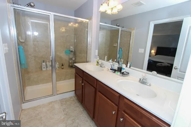 a bathroom with a double vanity sink mirror and shower