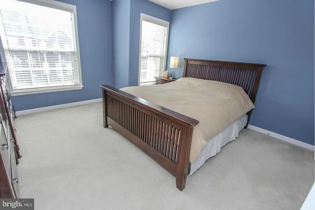 a bed sitting in a bedroom next to a window