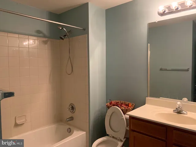 a bathroom with a sink a toilet a mirror and shower