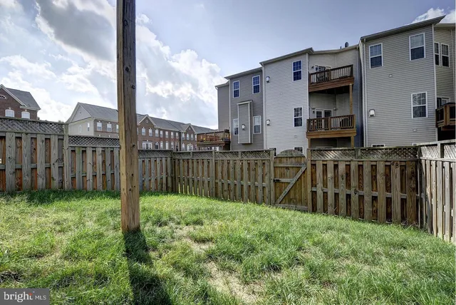 a view of a house with backyard and wooden fence