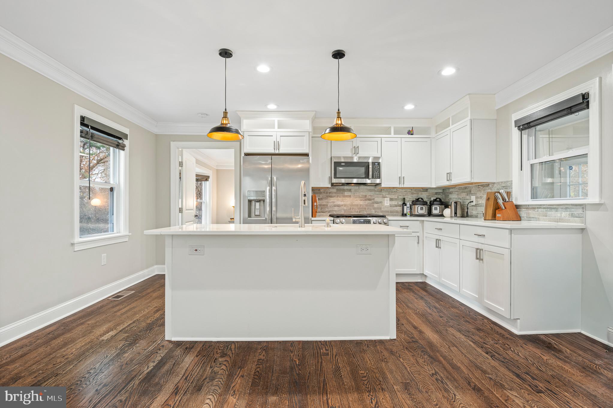 9217 Fowler Lane Lanham, MD 20706 - Photo 9 of 80 a kitchen with stainless steel appliances granite countertop wooden floors white cabinets and window