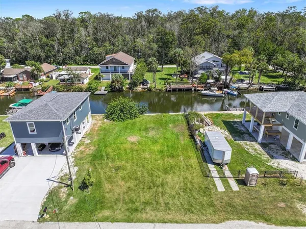 an aerial view of residential houses with outdoor space and lake view