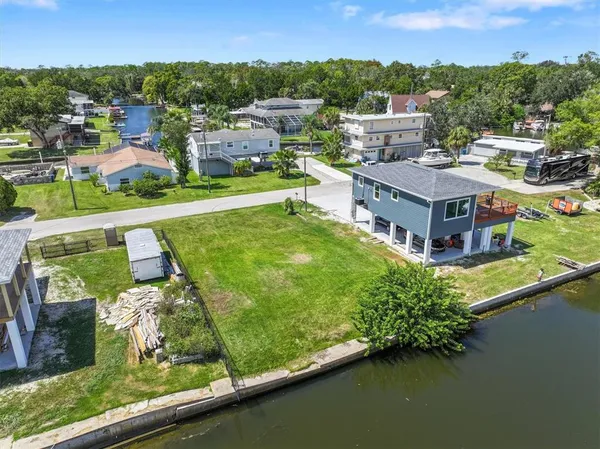an aerial view of a house with a garden and lake view