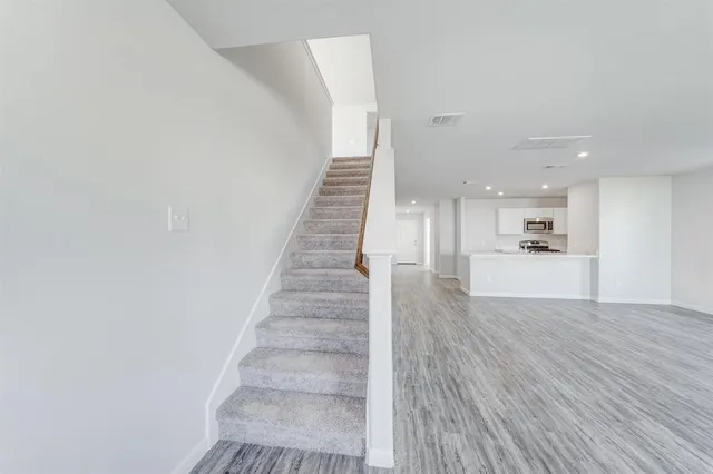 a view of entryway and kitchen with wooden floor