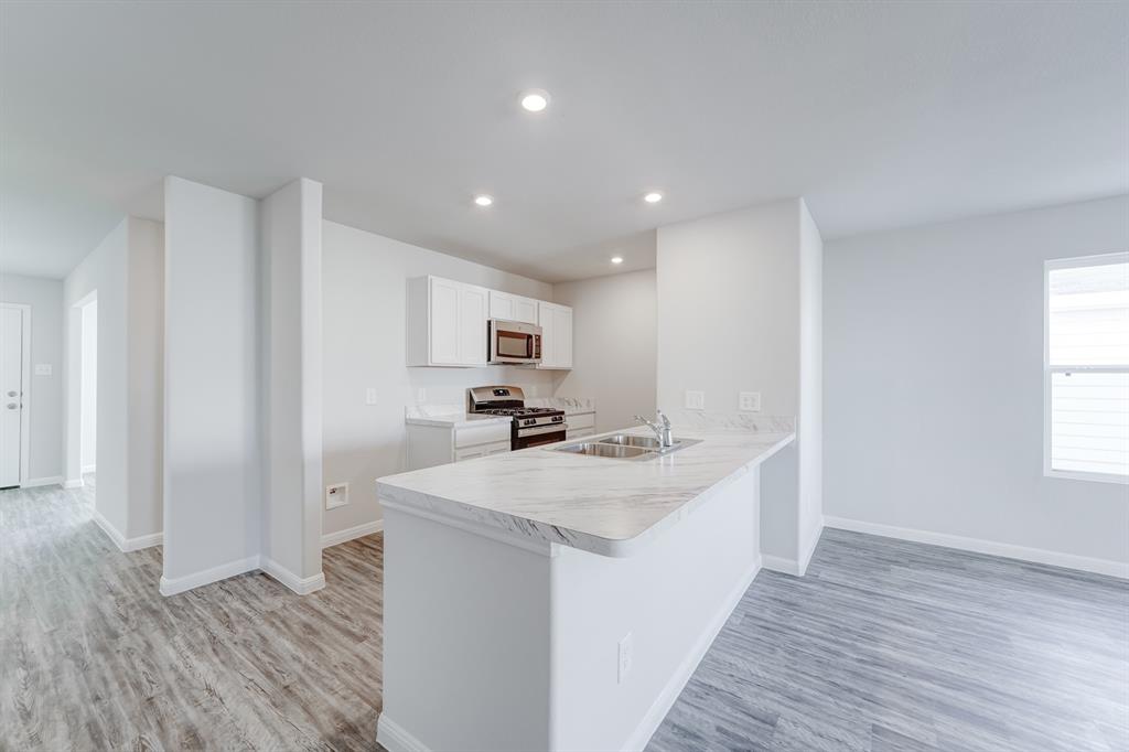 3525 Silver Springs Abilene, TX 79602 - Photo 8 of 20 a kitchen with a sink a stove cabinets and wooden floor