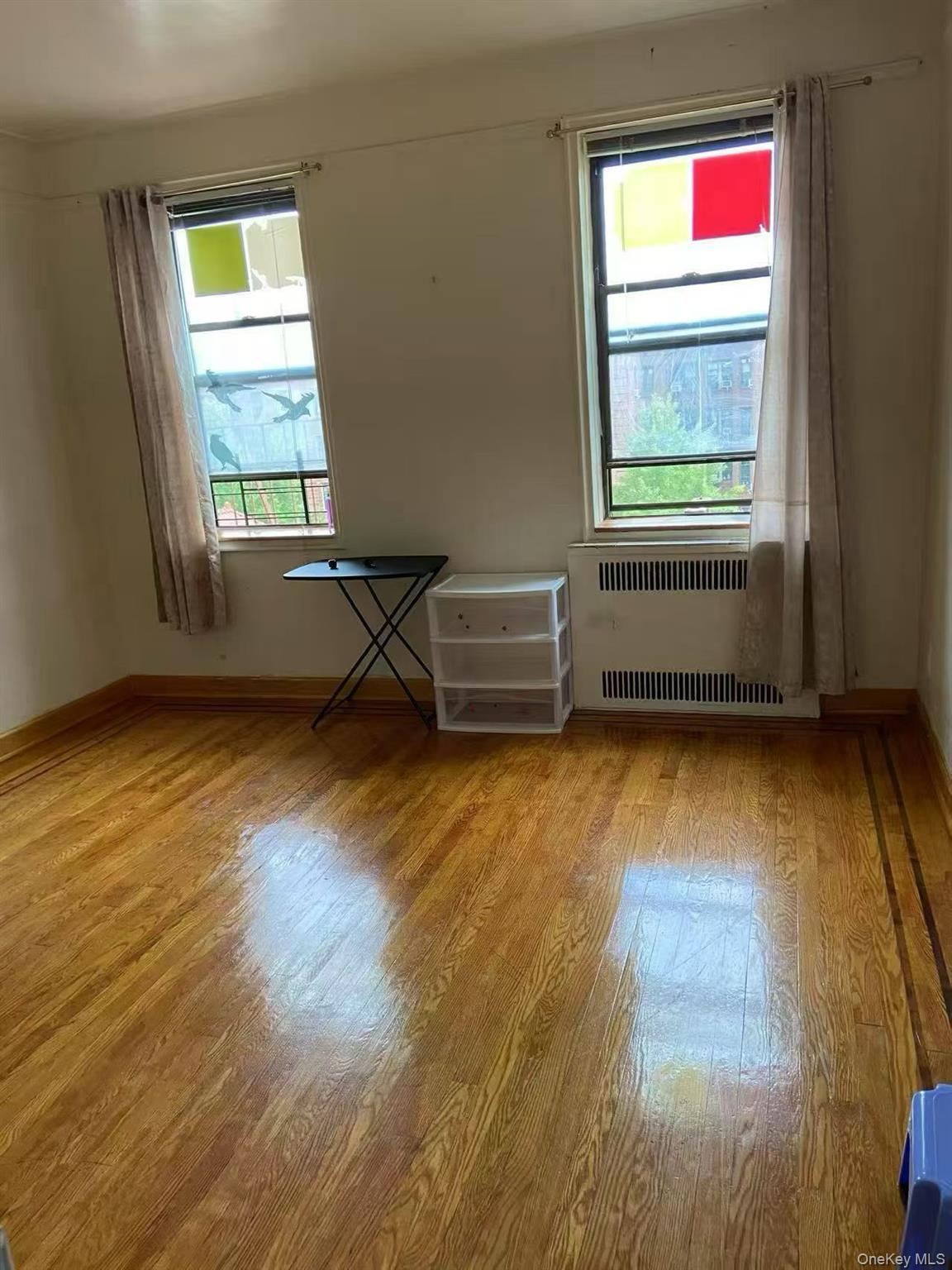 40-35 Ithaca Street, Unit 5B Queens, NY 11373 - Photo 9 of 10 Spare room with radiator and light wood-style flooring
