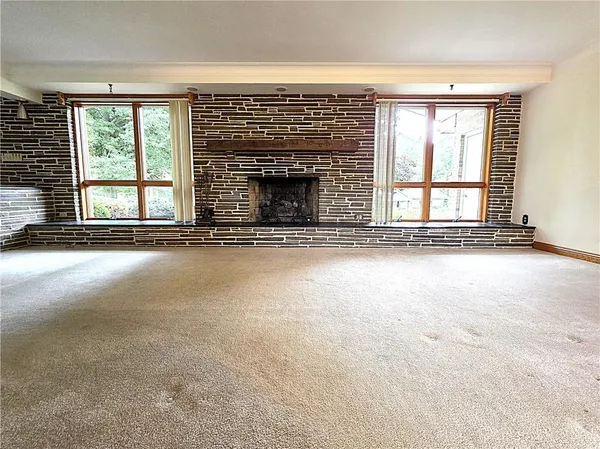 a view of an empty room with a fireplace and a window
