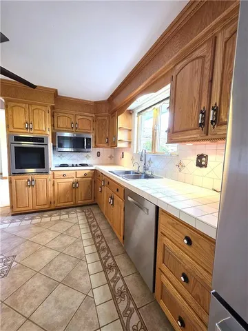 a kitchen with stainless steel appliances granite countertop a sink window and cabinets