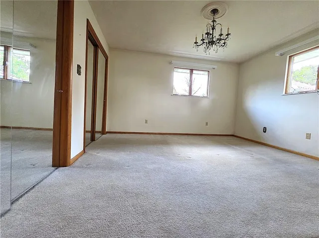 an empty room with windows and closet