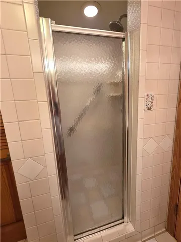 a bathroom with a glass door shower and a mirror