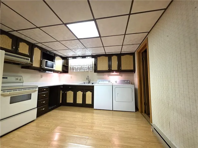 a kitchen with stainless steel appliances granite countertop a stove a sink and white cabinets
