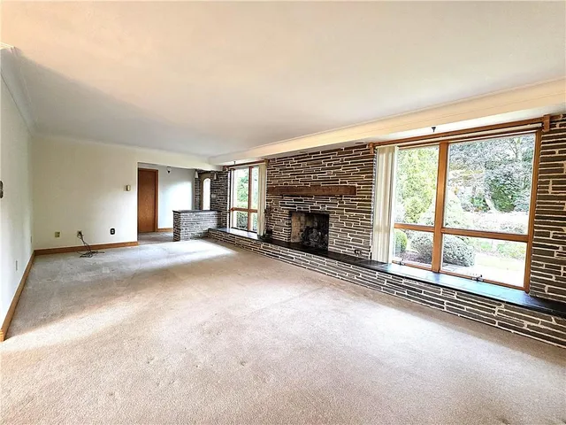 an empty room with fireplace and windows