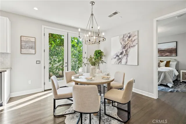 a dining room with furniture a chandelier and wooden floor