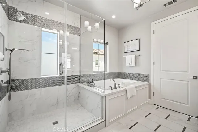 a bathroom with a double vanity sink a large mirror and shower