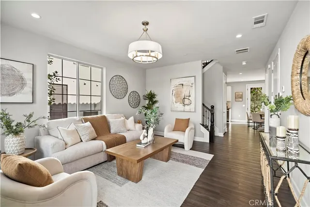 a living room with furniture a chandelier a rug and a window
