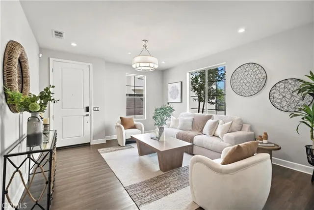 a living room with furniture a chandelier and a window